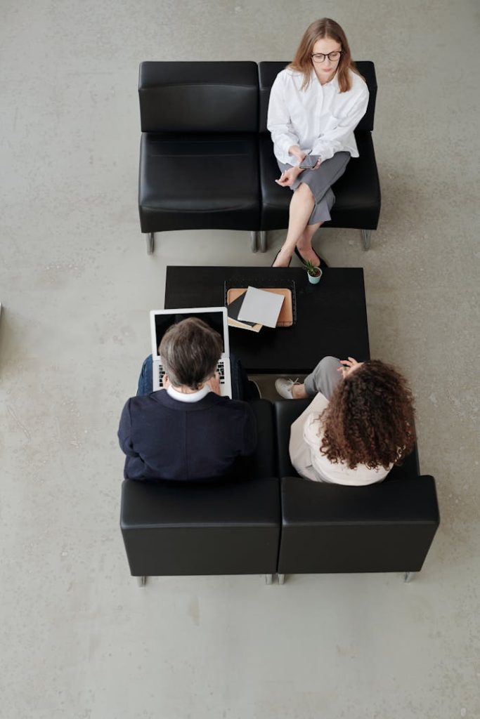 Overhead view of colleagues in a modern office, collaborating on laptops and notebooks.