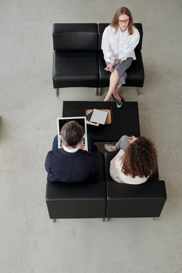 Overhead view of colleagues in a modern office, collaborating on laptops and notebooks.